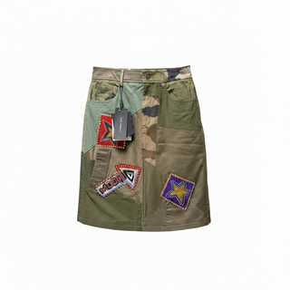Front view of a Dolce and Gabbana military green patchwork mini skirt with a red beaded star patch and original price tags.