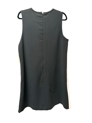 The rear profile view of the Victoria Beckham for Target tulip shift dress on a model. The design shifts to a solid, minimalist jet-black back panel fabric that contrasts beautifully with the white front, featuring a clean vertical seam lines layout and a discrete, hidden reverse zipper closure system.