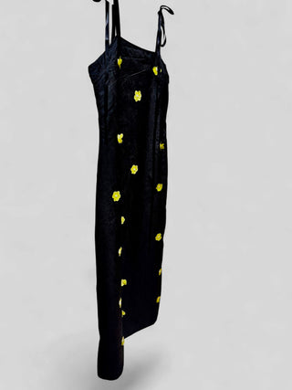 Side profile view of black Sister Jane Fanciful Flower midi dress showcasing adjustable double-tying satin ribbon shoulder straps.