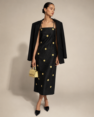 Front full-length view of DREAM Sister Jane Fanciful Flower black jacquard midi dress featuring yellow 3D beaded daisy flower appliqués.