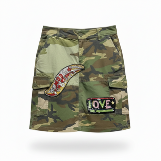 Front view of a Dolce and Gabbana military green patchwork mini skirt with a red beaded star patch and original price tags.